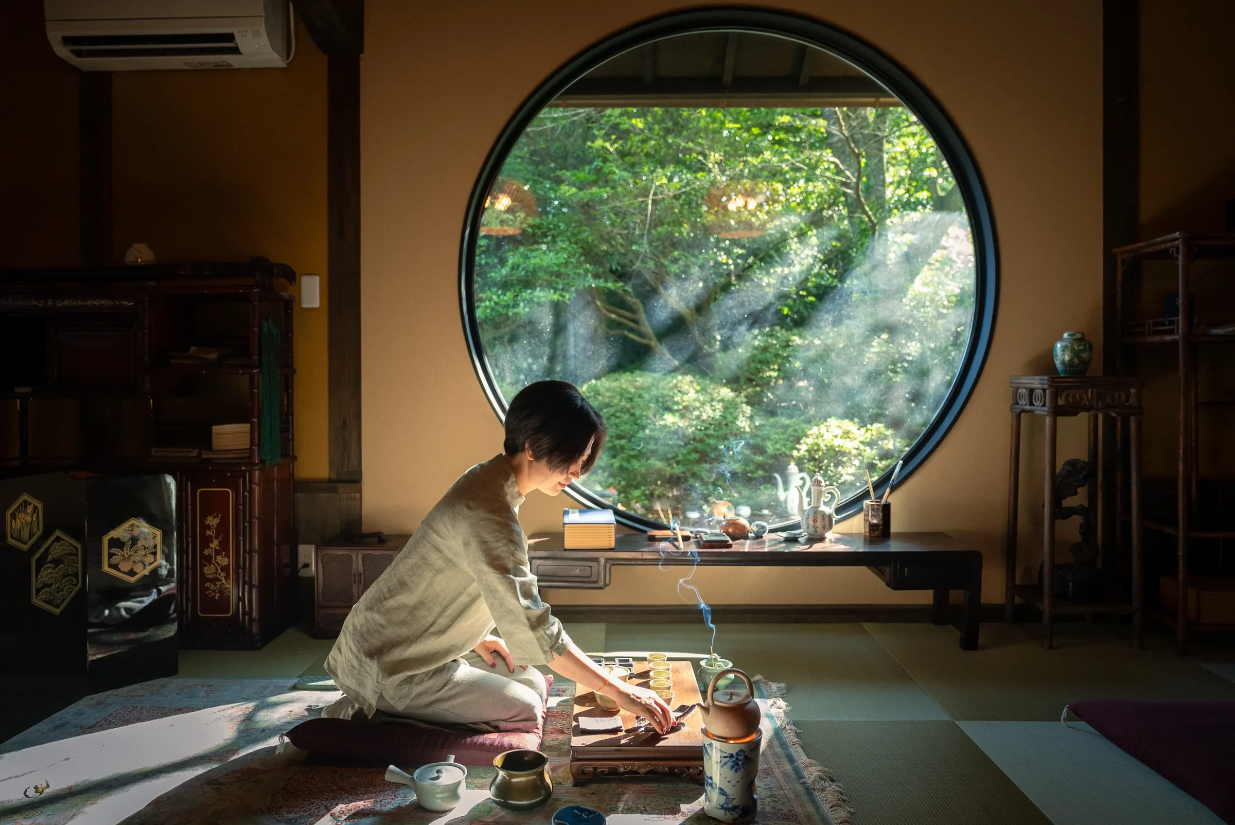 鸣凤堂茶室圆窗旁点茶的情景